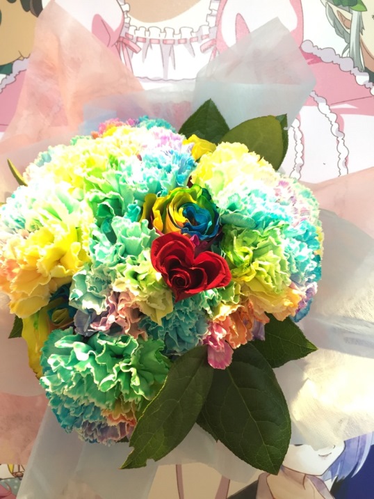 声優・歌手の田村ゆかりさんのイベント『田村ゆかり BIRTHDAY ♡ LIVE 2018 *Tricolore ♡ Plaisir* 』( 東京 武蔵野の森 総合スポーツプラザ メインアリーナ開催)にて、ファン一同さんから贈られましたHappy Birthdayのお祝いフラワースタンドの形パネル中心に描かれているキャラには、レインボーカラーのお花の花束を持っているかのように飾っています♪