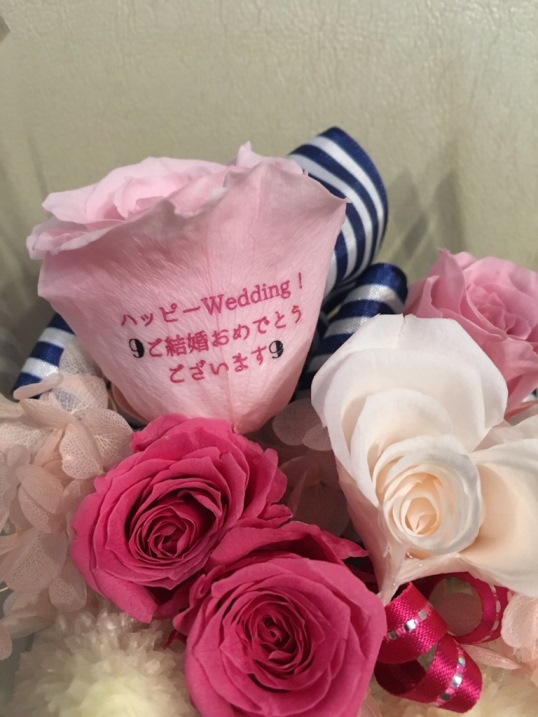 ご友人の結婚祝いに贈られました、愛あるプリザーブドフラワーのアレンジメントのバラ1輪に、『ハッピーwedding　ご結婚おめでとうございます』と、ご依頼主様からのメッセージをのせました♪